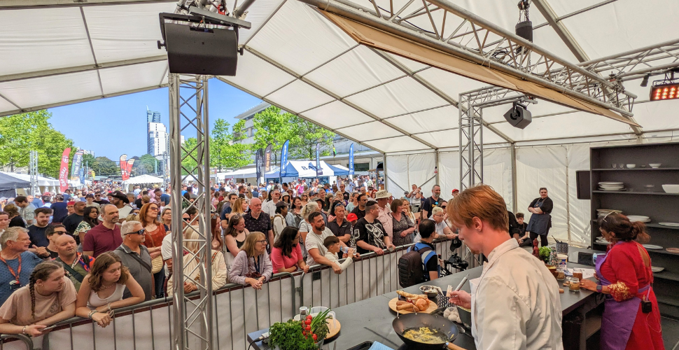 Cooking tent with people watching on at Flavour Fest 